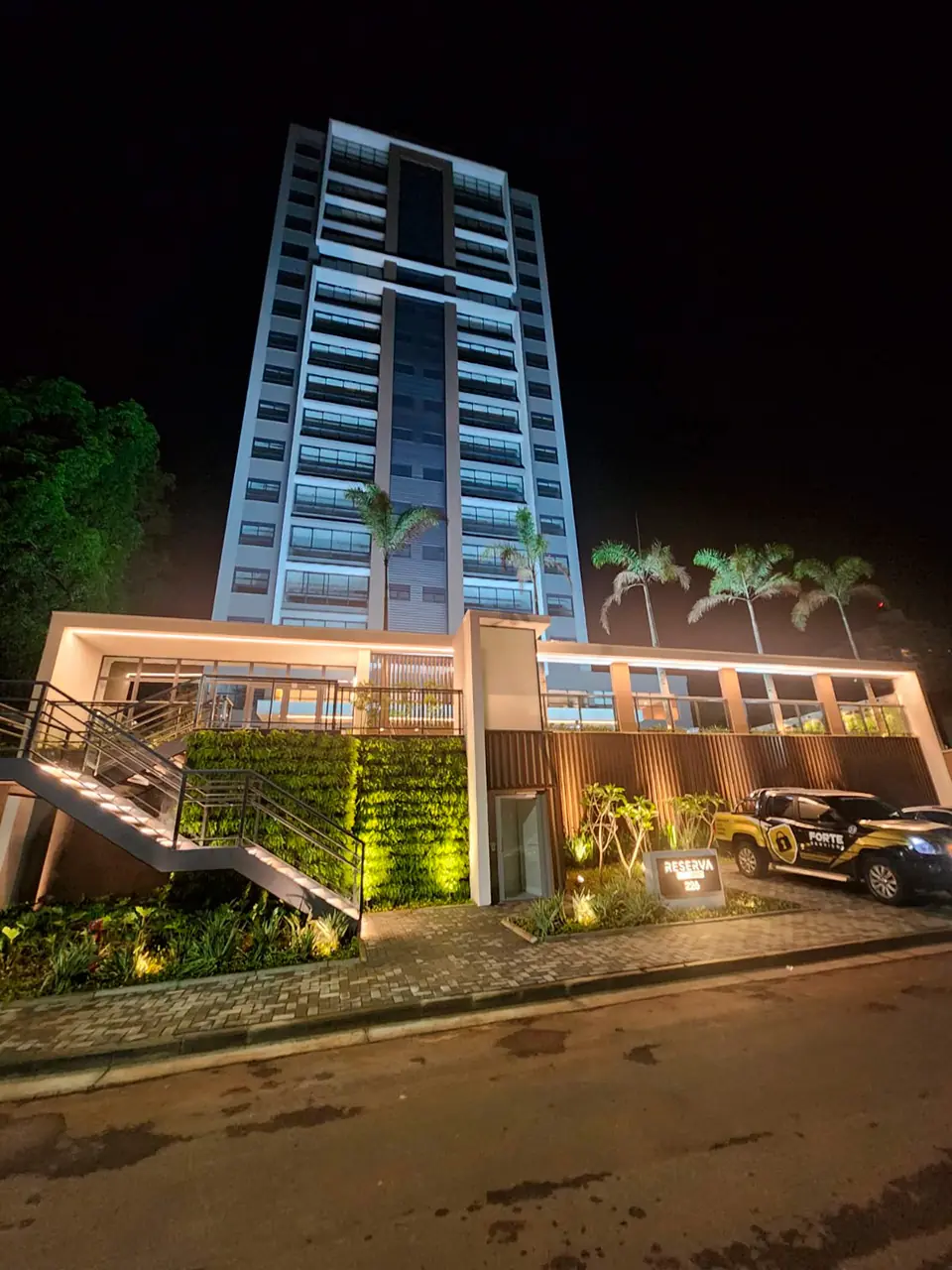 Foto real do edifício Reserva Bela Vista concluído, fachada iluminada à noite, em Mogi Guaçu